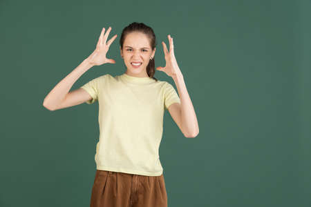 Caucasian young womans portrait isolated over green studio background with copyspaceの写真素材