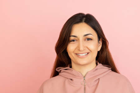 Young womans portrait on pink studio background. Concept of human emotions, facial expression,...
