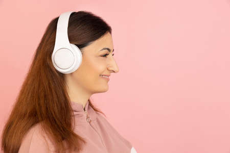 Young womans portrait on pink studio background. Concept of human emotions, facial expression, youth, sales, ad.の写真素材
