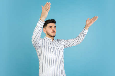 Young mans portrait on blue studio background. Concept of human emotions, facial expression, youth, sales, ad.の写真素材
