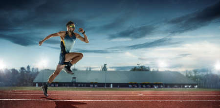 Professional male runner, jogger on stadium background. Caucasian fit athlete practicing, training...