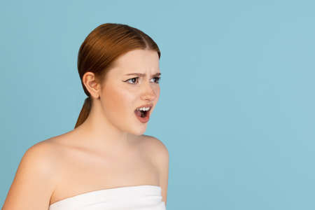 Close-up Caucasian womans portrait isolated over blue studio background with copyspace for ad. Concept of beauty, health.の写真素材