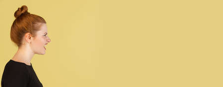 Close-up Caucasian womans portrait isolated over yellow studio background with copyspace for ad....