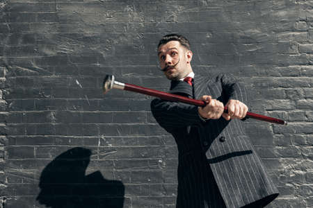 Portrait of young man in the image of greatest painter, artist isolated on gray brick background....