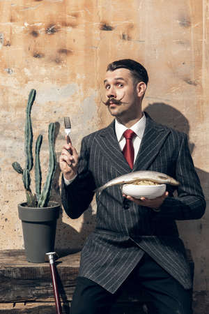 Portrait of young man in the image of greatest painter, artist isolated on light background. Retro...