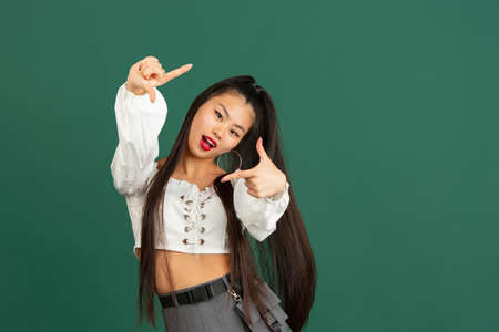 Asian young womans portrait isolated over color studio background with copyspace