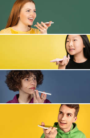 Communication Concept. Couple talking on phone holding gadget near mouth, posing on studio wall