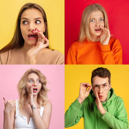 Secret, gossip concept. Young men and women whispering a secret behind hands. Business people isolated on trendy studio background.の写真素材