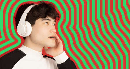 Asian young mans portrait on green red striped background. Concept of human emotions, facial expression, youth, sales, ad.の写真素材