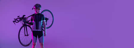 Cyclist riding a bicycle isolated against neon backgroundの写真素材