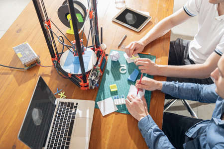 New generation of 3D printing machine for plastic. People using printer in small spaces, office or private use. New technology, innovation, equipment, industry, engineering, business concept. Top viewの写真素材