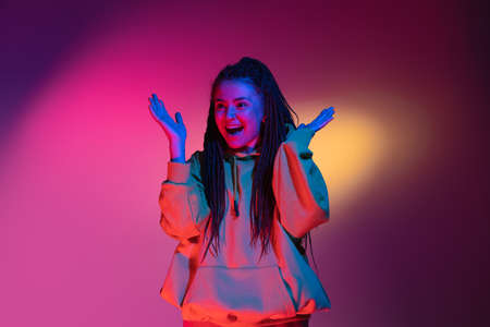 Young womans portrait on gradient colors studio background in neon. Concept of human emotions.