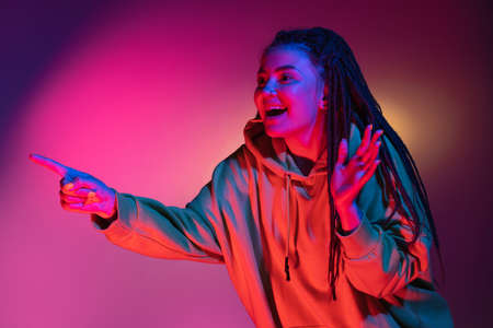 Young womans portrait on gradient colors studio background in neon. Concept of human emotions.
