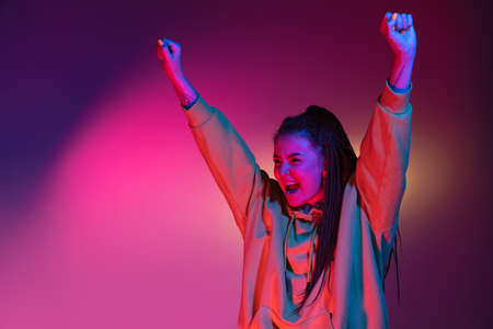 Young womans portrait on gradient colors studio background in neon. Concept of human emotions.の写真素材