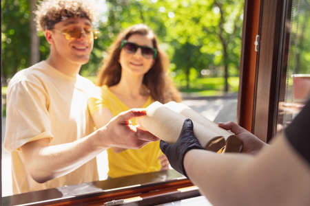 Happy attractive young couple romantically eating a fresh pizza outdoors.