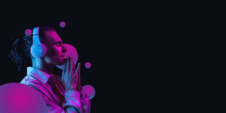 Young handsome man isolated over dark background in neon light. Concept of beauty, fashion,ad. Flyerの写真素材