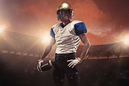 Young man american football player posing at stadium during evening match. Action, activity, sportlife concept. Flyer for ad, design.の写真素材
