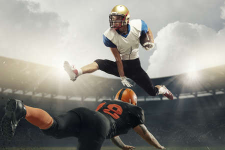 Two professional american football players at stadium in motion at stadium. Action, activity, sportlife concept. Flyer for ad, design.の写真素材