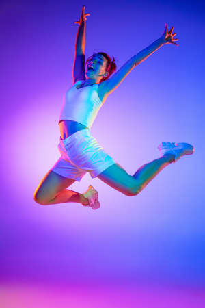 Caucasian young womans portrait on dark studio background in neon. Concept of human emotions, facial...