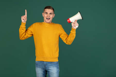 Portrait of young Caucasian man posing isolated over green studio background with copyspace for ad....