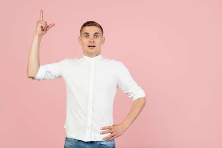 Portrait of young Caucasian man posing isolated over pink studio background with copyspace for ad. Concept of human emotionsの写真素材