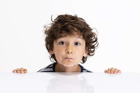 Close-up portrait of Caucasian preschool boy isolated on white studio background. Copyspace. Childhood, education, emotions conceptの写真素材