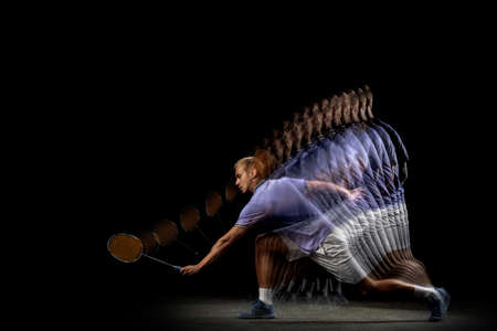 One young male badminton player, shuttler training isolated on dark background. Stroboscope effect.の写真素材
