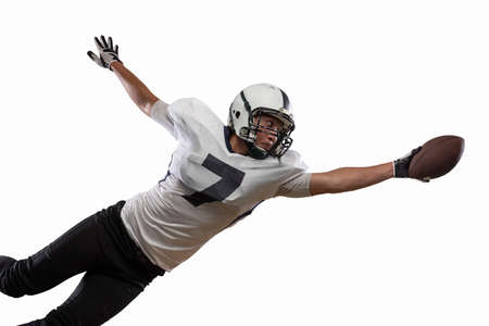 Portrait of American football player catching ball in jump isolated on white studio background.