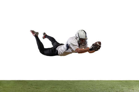 Portrait of American football player catching ball in jump isolated on white studio background.の写真素材