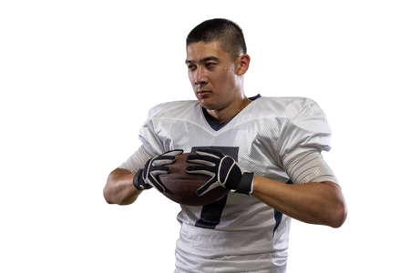 Close-up young American football player, athlete posing isolated on white studio background. Concept...