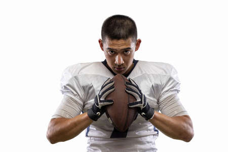 Close-up young American football player, athlete posing isolated on white studio background. Concept of professional sport, championship, competition.の写真素材