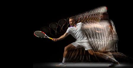 Portrait of young man, male tennis player in motion and action isolated on dark background. Stroboscope effect.の写真素材