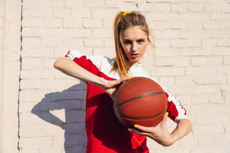 Beautiful adorable young girl in retro 90s fashion style, outfits posing on stairs, outdoors. Concept of eras comparison, beauty, fashion and youth.の写真素材