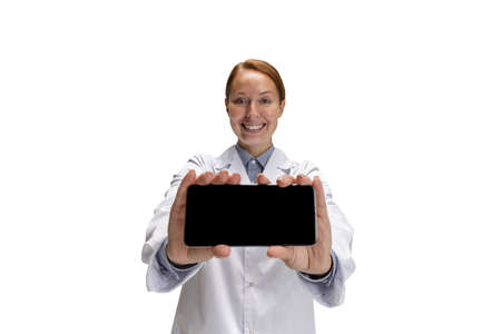 Using phone. Portrait of female doctor, therapeutic or medical advisor showing smartphone screen....