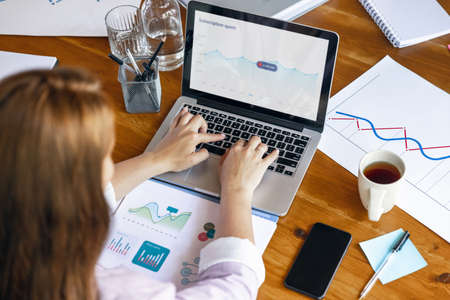 Close up female hands during working office day. Using laptop, modern gadgets. Remote working....