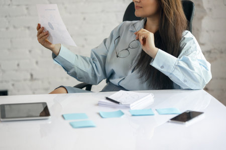 Young Caucasian woman, business lady during working office day. Using laptop, modern gadgets. Remote...
