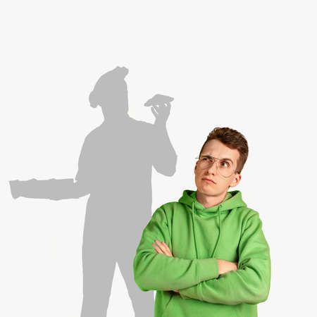 Young Caucasian man thinking about his childhood dream of becoming cook. Shadow of dreams on the...