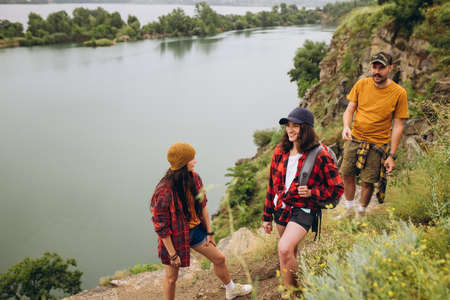 Delightful landscapes. Young people, friends walking, strolling together outskirts of city, in summer forest, meadow. Active lifestyle, friendship, care, ecology conceptの写真素材