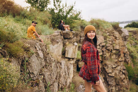 Group of friends, young men and women walking, strolling together outskirts of city, in summer...