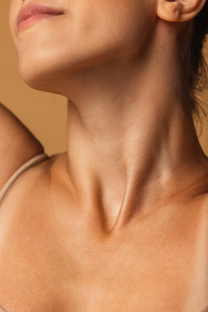 Close up female neck, collarbones isolated on pink studio background. Beautiful caucasian woman with well-kept skin.の写真素材