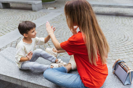 Two people, mother and little cute son strolling at street, trade square in summer time, outdoors. Family time, togehterness, parenting and happy childhood concept.の写真素材