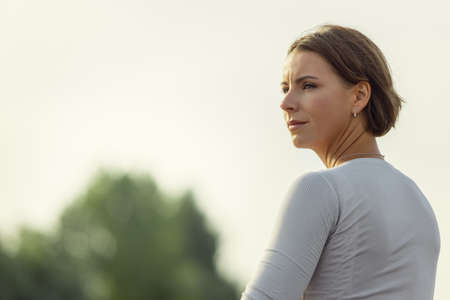 Close-up portrait of young Caucasian woman, sportsman practicing, training alone at summer evening, outdoors. Active life, sport, leisure activity conceptの写真素材
