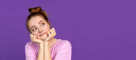 Half-length portrait of young pretty girl isolated on purple, lilac color studio background. Concept of human emotions, facial expression, natural beauty, youthの写真素材