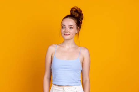 Sweet young pretty girl isolated on yellow studio background. Female fashion model in casual...