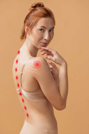 Perfect slim tanned young girl or fit naked woman at studio. Posture correction, sports, healthy...