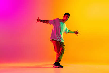 Portrait of young stylish man, break dancing dancer training in casual clothes isolated over...