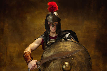 Close up of medieval person, brutal man, warrior or knight in war equipment isolated on vintage dark...
