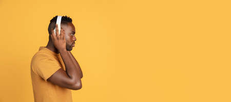Portrait of African young man in casual clothes isolated on yellow color studio background. Concept...