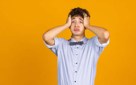 Portrait of young curly man isolated over yellow studio background with copyspace for ad. Concept of human emotions, fashion, beauty, youthの写真素材