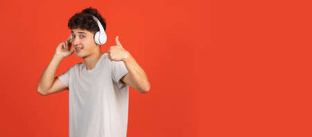 Asian mans portrait isolated over red studio background with copyspace for ad. Concept of human...